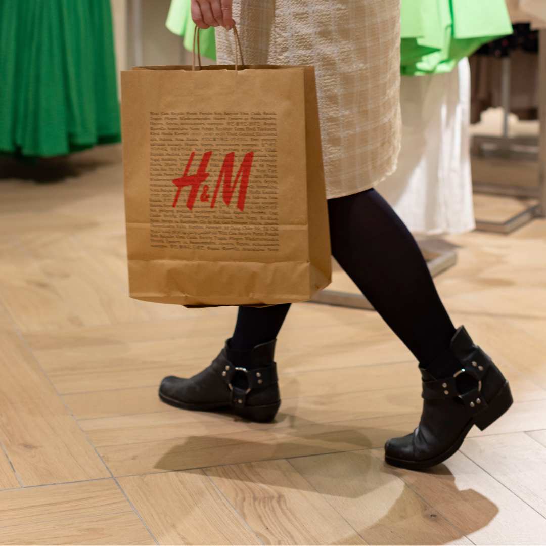 Kunde har handlet i H&M på Amager og går ud med en pose i hånden.